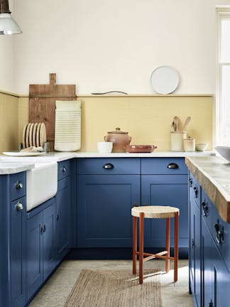 Kitchen with deep indigo (Woad) kitchen units and contrasting yellow tiles and upper wall.