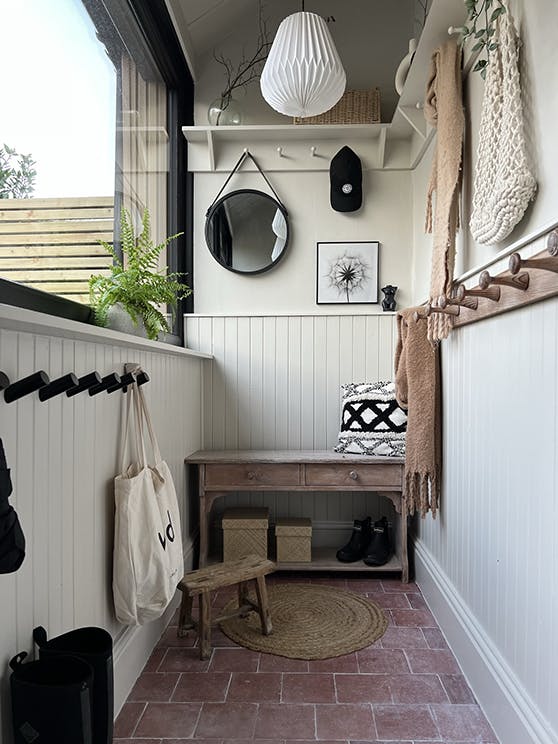 Home entrance with beige walls and paneling painted in 'Slaked Lime - Deep', alongside red tile flooring.