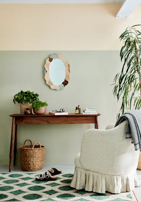 Home study with warm neutral (Light Beauvais) upper wall, grey green (Tracery II) lower wall and armchair and wooden desk.