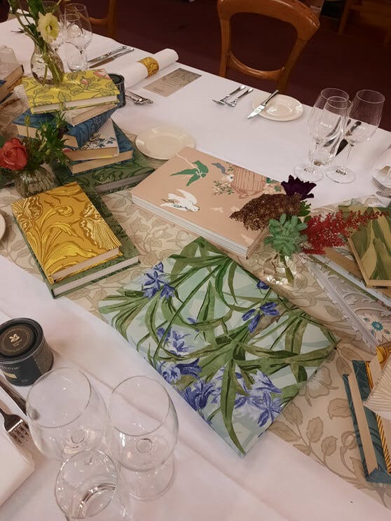 Books covered with National Trust Papers III patterns used as table centerpieces at the Little Greene press event.