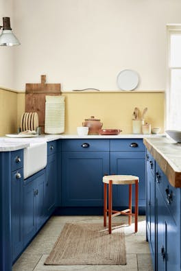 Kitchen with deep indigo (Woad) kitchen units and contrasting yellow tiles and upper wall.