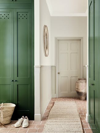 Hallway painted in graduated shades of the pale neutral shade 'Portland Stone' with contrasting 'Dark Brunswick Green' cupboards either side. 