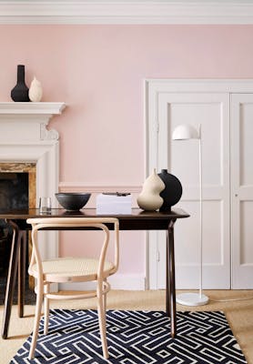 Home office with pale pink (Pink Slip) walls and contrasting neutral woodwork alongside a fireplace, wooden desk and chair.