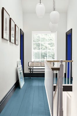 Hallway with an Air Force Blue painted floor, contrasting white (Shallows) walls and a window at the end of the corridor.