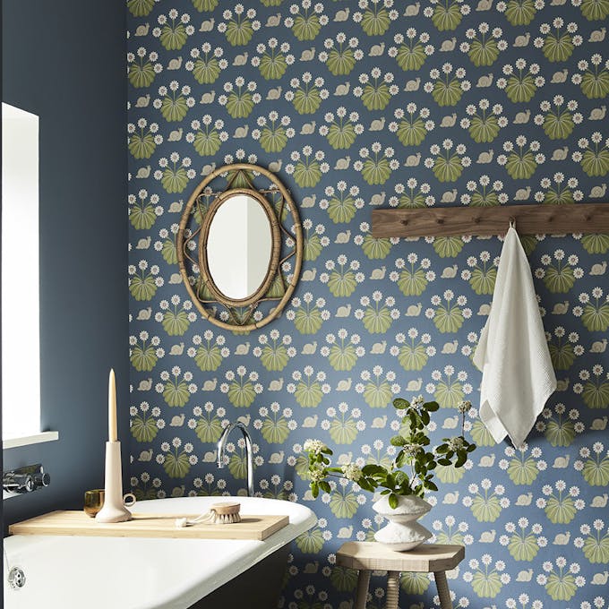 Bathroom with snail-printed wallpaper (Burges Snail - Juniper) on back wall and deep blue (Juniper Ash) on right wall.