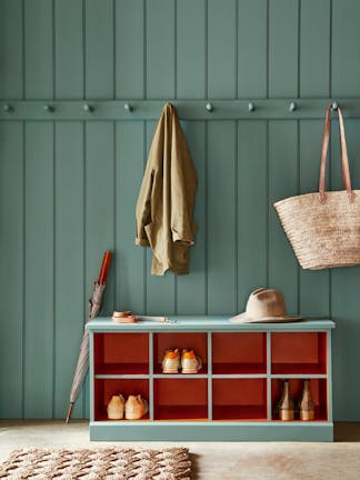 Paneled mudroom painted in green shade, Pleat, with contrasting deep red (Heat) shelving.