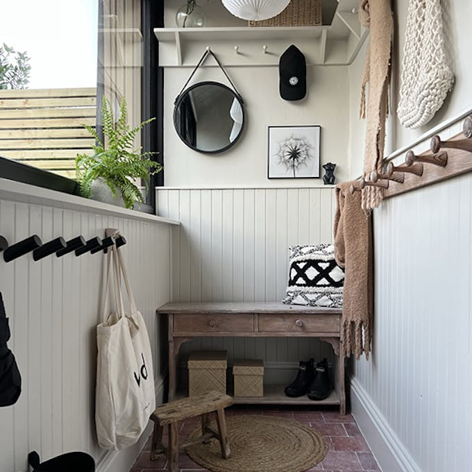 Home entrance with beige walls and paneling (Slaked Lime - Deep), alongside a contrasting black window frame in Jack Black.