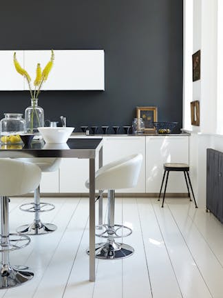 Rich black (Lamp Black) kitchen with bright white units and stools next to a black table.