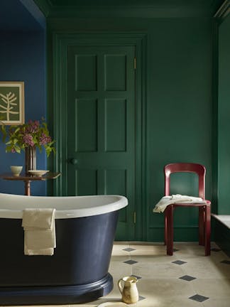 Bathroom painted in rich green shade 'Mid Azure Green' with a deep blue bathtub and vibrant blue 'Deep Space Blue' on the left hand wall.