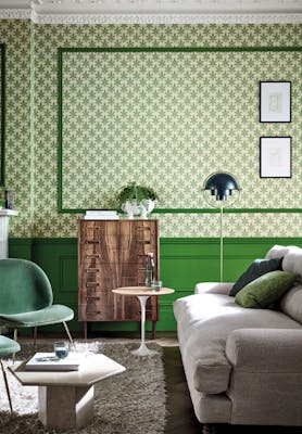 Living room featuring leaf wallpaper (Clutterbuck - Lodge) alongside green panelling and ceiling with coving.