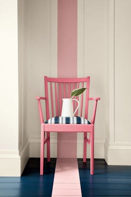 Dark pink (Carmine) chair with a dusky pink stripe painted from the wall down to the navy blue panelled floor.