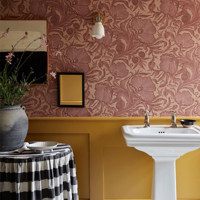 Bathroom featuring a white freestanding sink in front of pink Poppy Trail - Masquerade wallpaper above Yellow-Pink panelling.