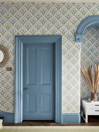 Hallway with a door and baseboards painted in a muted blue (Grey Stone) and a patterned wallpaper (Hencroft - Blue Primula).