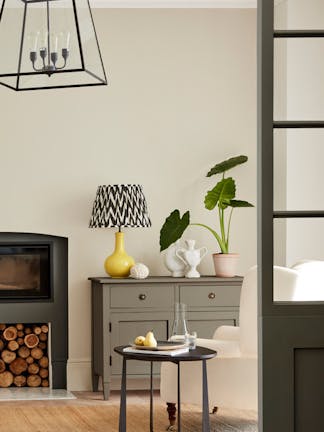 Neutral living space painted in 'Portland Stone' with grey drawers, fireplace and an armchair.