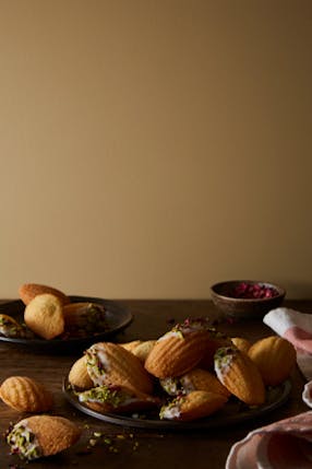 Madeleines on a plate with wall painted in muted gold shade 'Madeleine'.