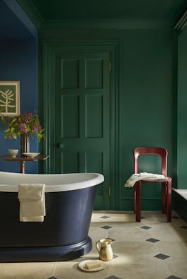 Bathroom painted in rich green shade 'Mid Azure Green' with a deep blue bathtub and vibrant blue 'Deep Space Blue' on the left hand wall.