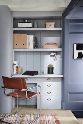 Home office space painted in cool neutral 'Obscura' and dark blue 'Juniper Ash', with a desk and office chair.