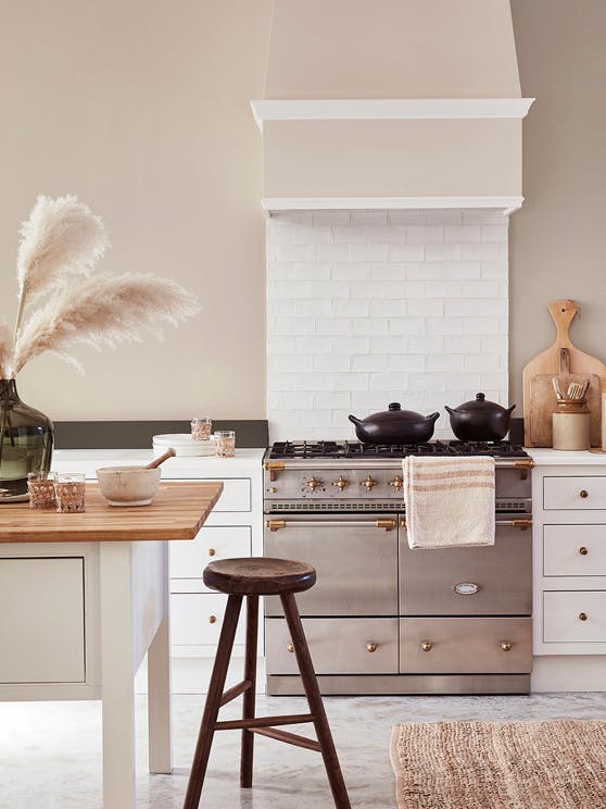 Country-style kitchen with neutral walls, white cabinets, stainless steel oven and a kitchen island.