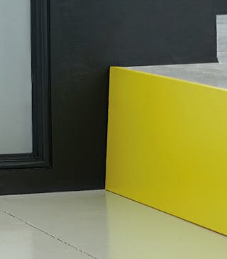 White stairs in a hallway with bright yellow (Trumpet) contrasting stair risers and a black and grey baseboard.