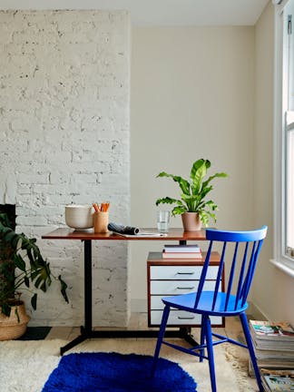 Study featuring neutral beige (Joanna) walls, a bright white (Loft White) ceiling, and a wooden desk and deep blue chair.