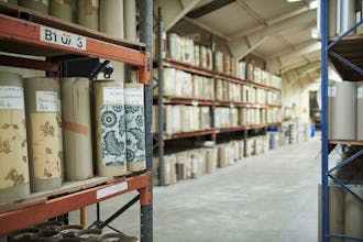 Shelves in Little Greene's factory holding wallpapers wrapped in brown paper.