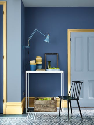 Hallway featuring blue walls painted in muted indigo 'Woad' and grey-blue 'Grey Stone', and bright yellow door frames.