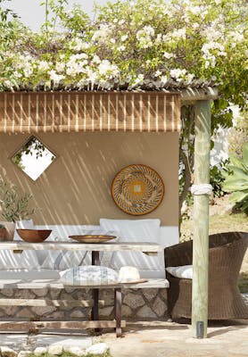 Outdoor dining area painted in the neutral color Lute, with a cushioned seating area painted in off-white Flint.