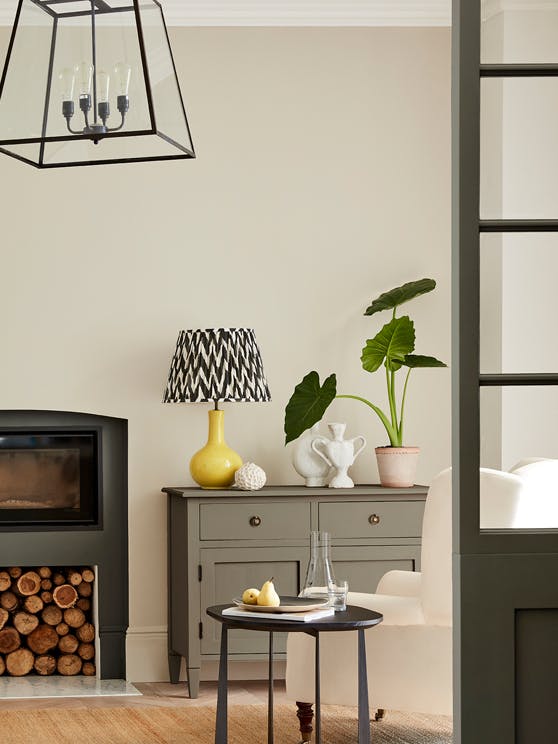 Neutral living space painted in 'Portland Stone' with grey drawers, fireplace and an armchair.