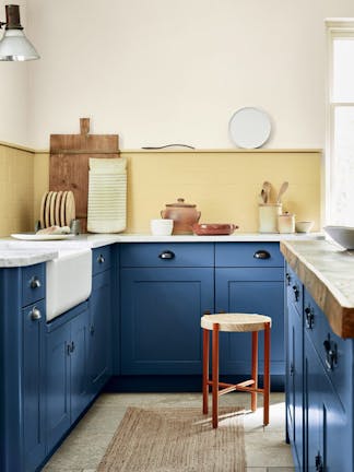 Kitchen with deep indigo (Woad) kitchen units and contrasting yellow tiles and upper wall.