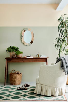 Home study with warm neutral (Light Beauvais) upper wall, grey green (Tracery II) lower wall and armchair and wooden desk.